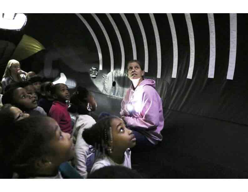 Meet “Nile”, the Inflatable Humpback Whale Children and an instructor looking up at the inflatable whale belly