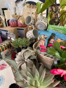 A modern color photograph of a store display. There are mugs, air plants, cards and many other items.